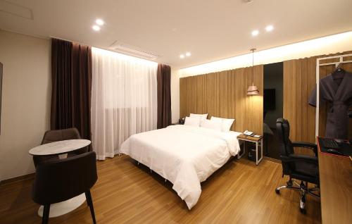 a hotel room with a bed and a table and chairs at Brown Dot Hotel Sinan in Gwangju