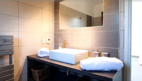 łazienka z białą umywalką i lustrem w obiekcie Villa Terra Vecchia, 6 ou 12 personnes, vue imprenable, piscine chauffée w mieście Porto-Vecchio