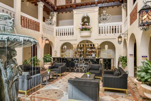 a lobby of a hotel with chairs and tables at The Villa Casa Casuarina in Miami Beach