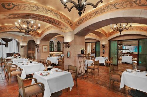 a restaurant with white tables and chairs and ceilings at The St. Regis Beijing in Beijing