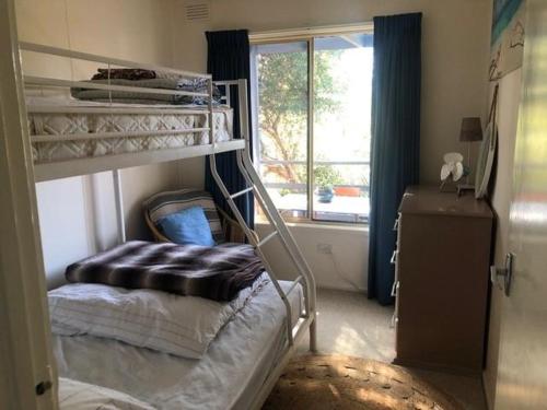 a bedroom with bunk beds and a window at Beach Cottage in Ventnor in Ventnor