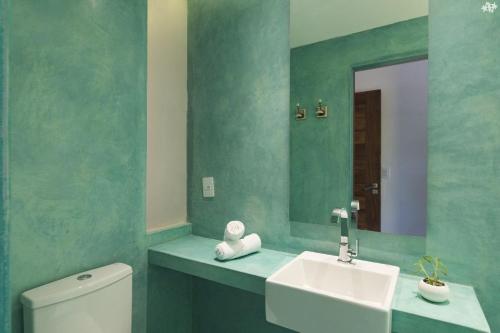 y baño con aseo, lavabo y espejo. en Sensacional flat no Laguna Serena, en Pipa