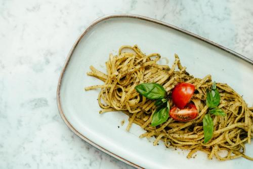 a plate of spaghetti with a tomato on top at Residence Inn by Marriott Ghent in Ghent