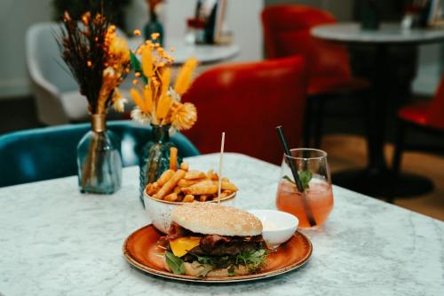 a sandwich and french fries on a table with a drink at Residence Inn by Marriott Ghent in Ghent