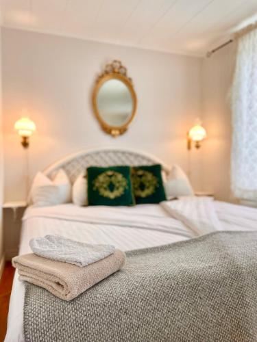 a bedroom with a bed with a mirror on the wall at Hotell & Restaurant Solliden in Stenungsund