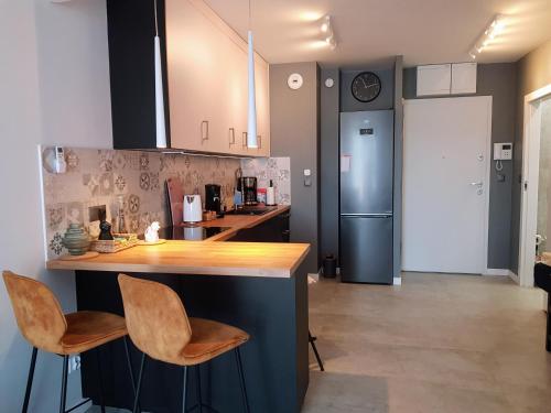 a kitchen with a counter and two stools at Harry’s Apartment/centrum/parking in Wrocław