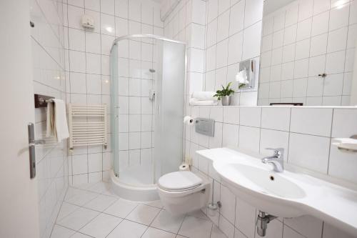 a bathroom with a toilet and a sink and a shower at City Hotel Miskolc in Miskolc