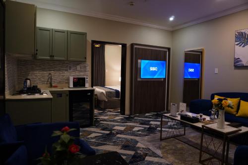 a room with a kitchen and a living room with a television at Swat Hotel Apartments 2 in Al Khobar