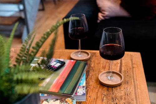 two glasses of red wine sitting on a wooden table at Unique, stylish and secluded home, with parking in the heart of historic York in York