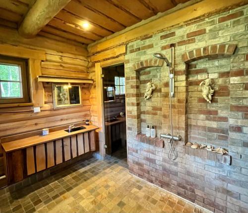 baño con ducha y pared de piedra. en Oanduaia saunamaja, en Oandu