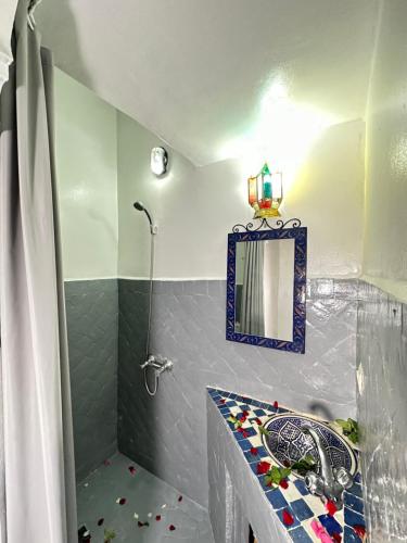 a bathroom with a shower and a sink and a mirror at Dar Khmissa Fes-Luxury Stay Fes Medina in Fès