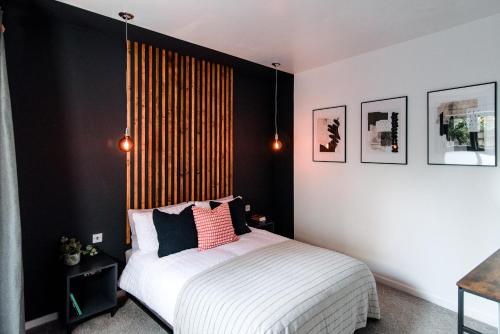 a bedroom with a bed with a black accent wall at Unique, stylish and secluded home, with parking in the heart of historic York in York