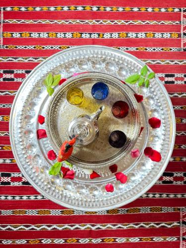 a silver plate with a glass plate with some food on it at Dar Khmissa Fes-Luxury Stay Fes Medina in Fès