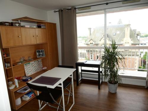 a room with a desk and a table and a window at Appartement Nickel et confortable in Rouen