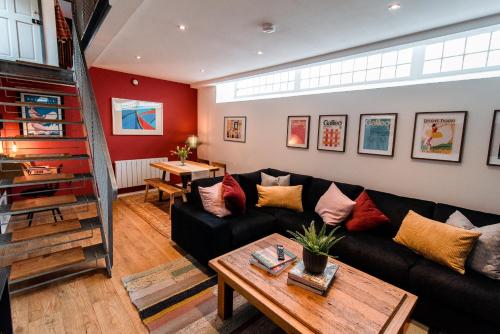 a living room with a black couch and a table at Unique, stylish and secluded home, with parking in the heart of historic York in York
