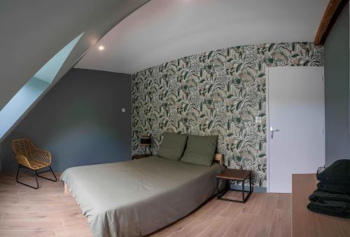 una camera da letto con un letto e una parete di Appartement centre - La Gacilly a La Gacilly