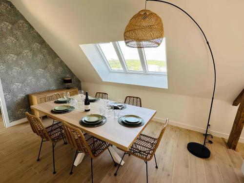 una sala da pranzo con tavolo e sedie di Appartement centre - La Gacilly a La Gacilly