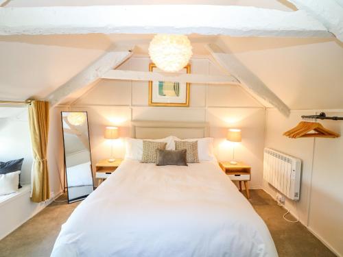 a bedroom with a large white bed and two lamps at Hillside in Torpoint