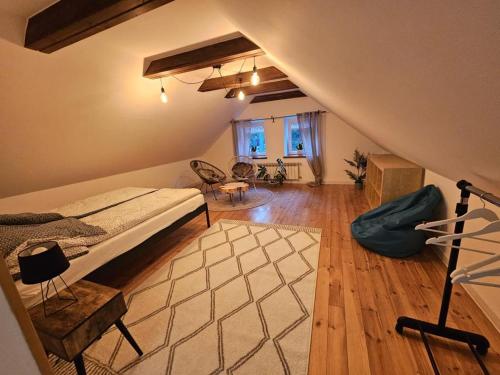 a attic room with a bed and a living room at Apartament w Centrum in Żuromin