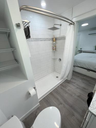 a bathroom with a shower and a toilet and a bed at Gardner Lake 2 Queen/1King/2 Bath/Laundry- Private in Salem