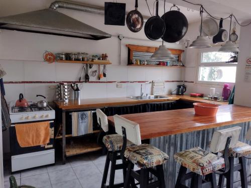 cocina con encimera de madera y fogones en la casa de gales habitación privada con baño en Puerto Madryn