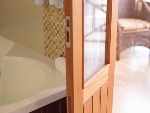 a bathroom with a bath tub next to a door at Pousada Suiça Mineira Centro in Monte Verde