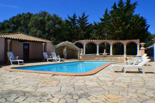 une piscine dans une cour avec des chaises et une maison dans l'établissement Domaine De Foresta, à Bonifacio