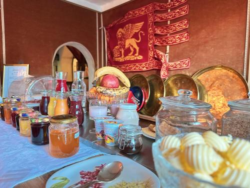a table with many jars of jam and food on it at Chasa de Capol - Historische Gaststätte & Weinkellerei in Sta Maria Val Müstair