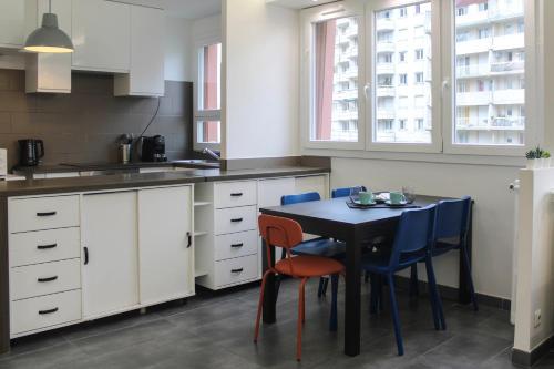 une cuisine avec une table et des chaises bleues. dans l'établissement Magnifique Appartement proche Paris, à Saint-Maurice