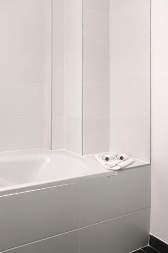 une salle de bain blanche avec une baignoire et un lavabo dans l'établissement Magnifique Appartement proche Paris, à Saint-Maurice