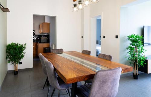 a dining room with a wooden table and chairs at Le Coin Vert in Hettange-Grande