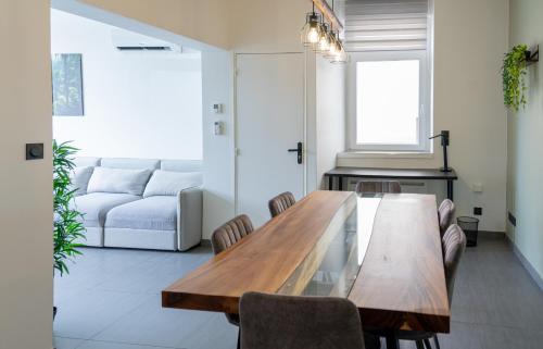 ein Wohnzimmer mit einem Holztisch und einem Sofa in der Unterkunft Le Coin Vert in Hettange-Grande