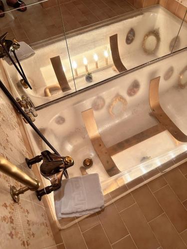 a bathtub in a bathroom with a towel in it at Chasa de Capol - Historische Gaststätte & Weinkellerei in Sta Maria Val Müstair