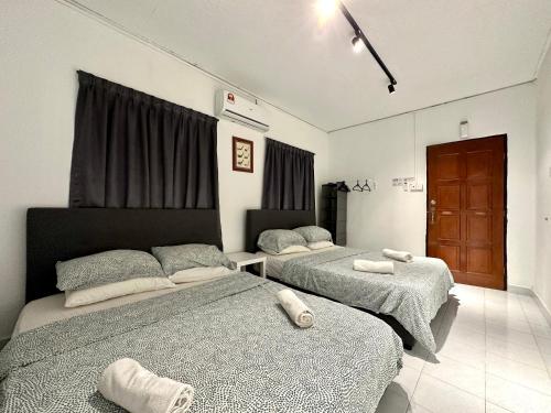 um quarto com 2 camas e toalhas em BNB Cozy Homestay @ Bdr Country Homes (Corner Hse) em Rawang