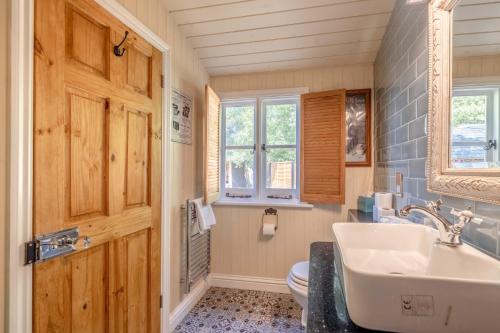 a bathroom with a sink and a toilet at Relaxing Retreat - The Shepherds Hut - Hot Tub in White Waltham