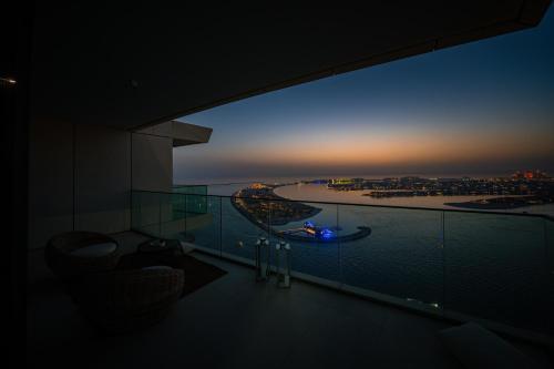 a room with a view of the ocean at sunset at Luxury Penthouse I 220 deg View of the Palm I Dubai Harbour I Private Beach in Dubai