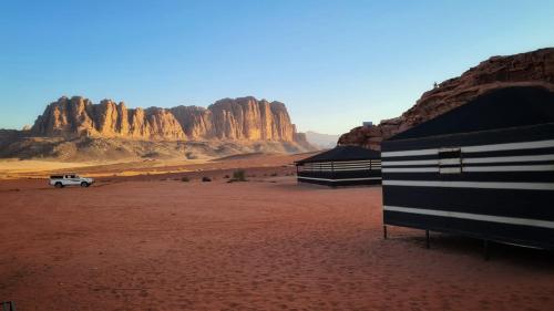 a sign in the middle of a desert with mountains at bedouin future camp in Wadi Rum