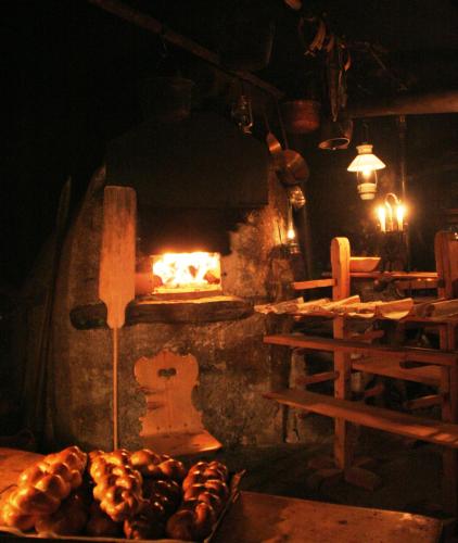 a stove with a fire in a room with bread at Chasa de Capol - Historische Gaststätte & Weinkellerei in Sta Maria Val Müstair
