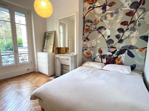 - une chambre avec un lit orné d'un mur fleuri dans l'établissement L'appartement Michel-Ange, à Paris
