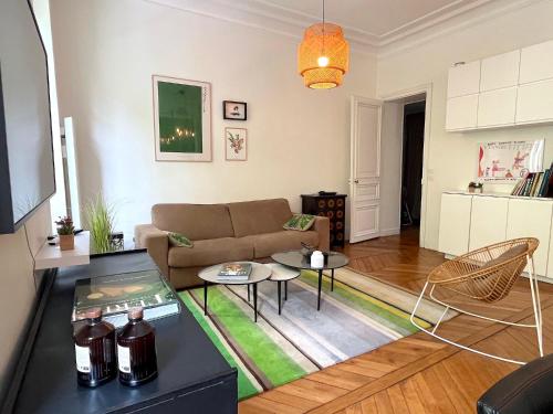 un salon avec un canapé et une table dans l'établissement L'appartement Michel-Ange, à Paris