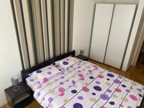 ein Schlafzimmer mit einem Bett mit Polka-Punkten darauf in der Unterkunft Apartman Kalina in Donje Mladice