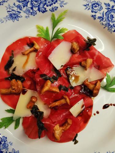 a white plate of food with tomatoes and cheese at Chasa de Capol - Historische Gaststätte & Weinkellerei in Sta Maria Val Müstair