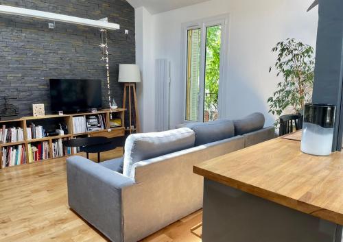 sala de estar con sofá y TV en La Rive - Charmant logement bord de Marne en Champigny-sur-Marne