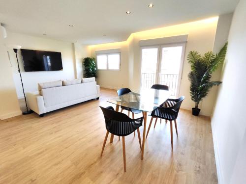 a living room with a table and chairs and a couch at Puertollano Central Park - by Pro Apartments - Free Parking in Puertollano