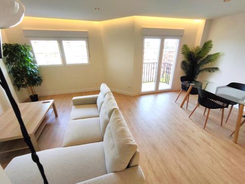 a living room with a couch and a table and chairs at Puertollano Central Park - by Pro Apartments - Free Parking in Puertollano