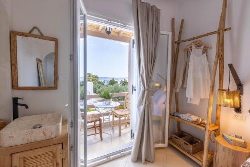 a bathroom with a glass door leading to a patio at Acoya Residences in Aliki