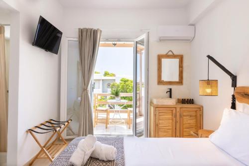 1 dormitorio con 1 cama y balcón en Acoya Residences, en Aliki