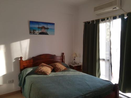 een slaapkamer met een bed met 2 kussens erop bij Departamento Colon Entre Rios in Colón