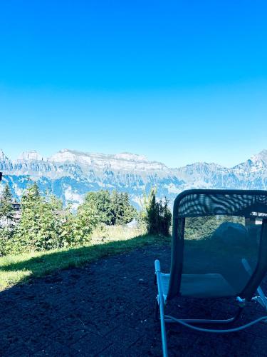 FlumserbergにあるFerienwohnung Arvenstrasse - CharmingStayの山の景色を望む丘の上に座る椅子