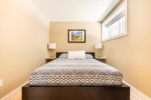 a bedroom with a bed and two lamps at Cougar Street Mountain Rental in Banff